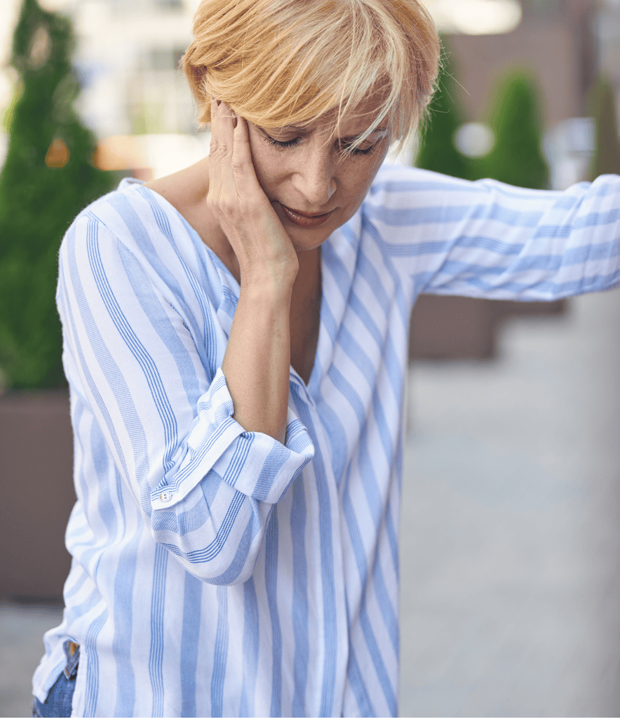 Woman experiencing menopause symptoms including fatigue and hot flashes while considering bioidentical hormone replacement therapy at AURSPA in Oakleaf Plantation, FL.