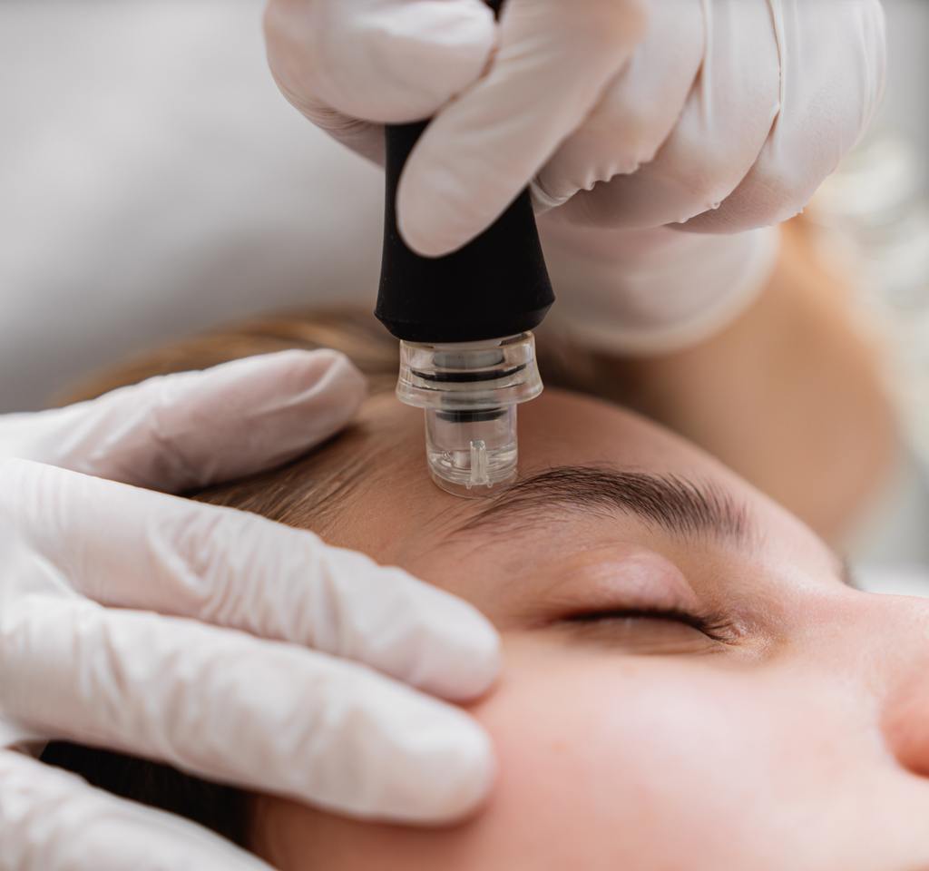 Licensed aesthetician performing a HydraFacial treatment to deeply cleanse, hydrate, and rejuvenate the skin at AURSPA near Jacksonville, FL.