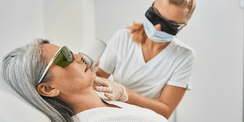 Provider performing an Aerolase laser facial on a client wearing protective eyewear.